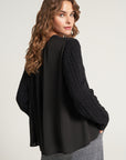 Knitted sweater with flowing insert on the back