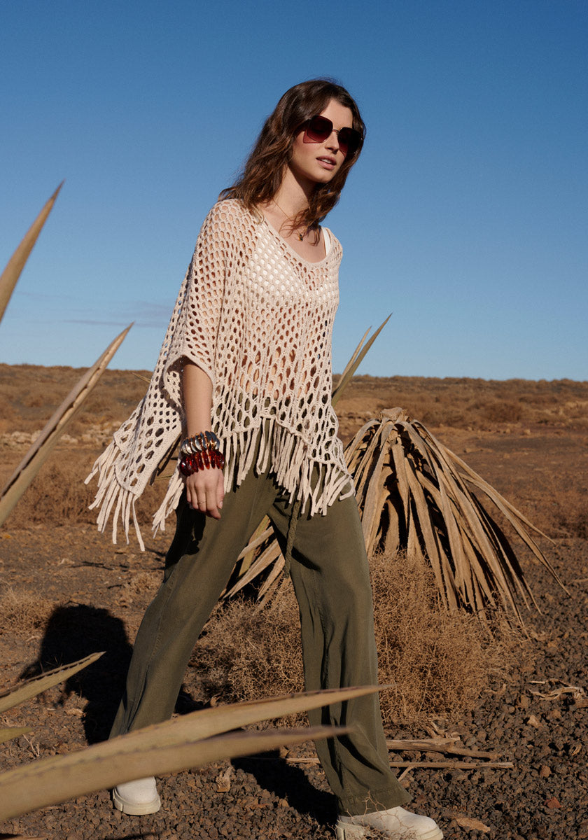 Poncho with net pattern and fringes